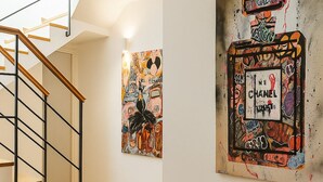 A modern interior with a staircase, wooden flooring, and artwork on the walls. - La Terrazza del Garraffello (Palermo)