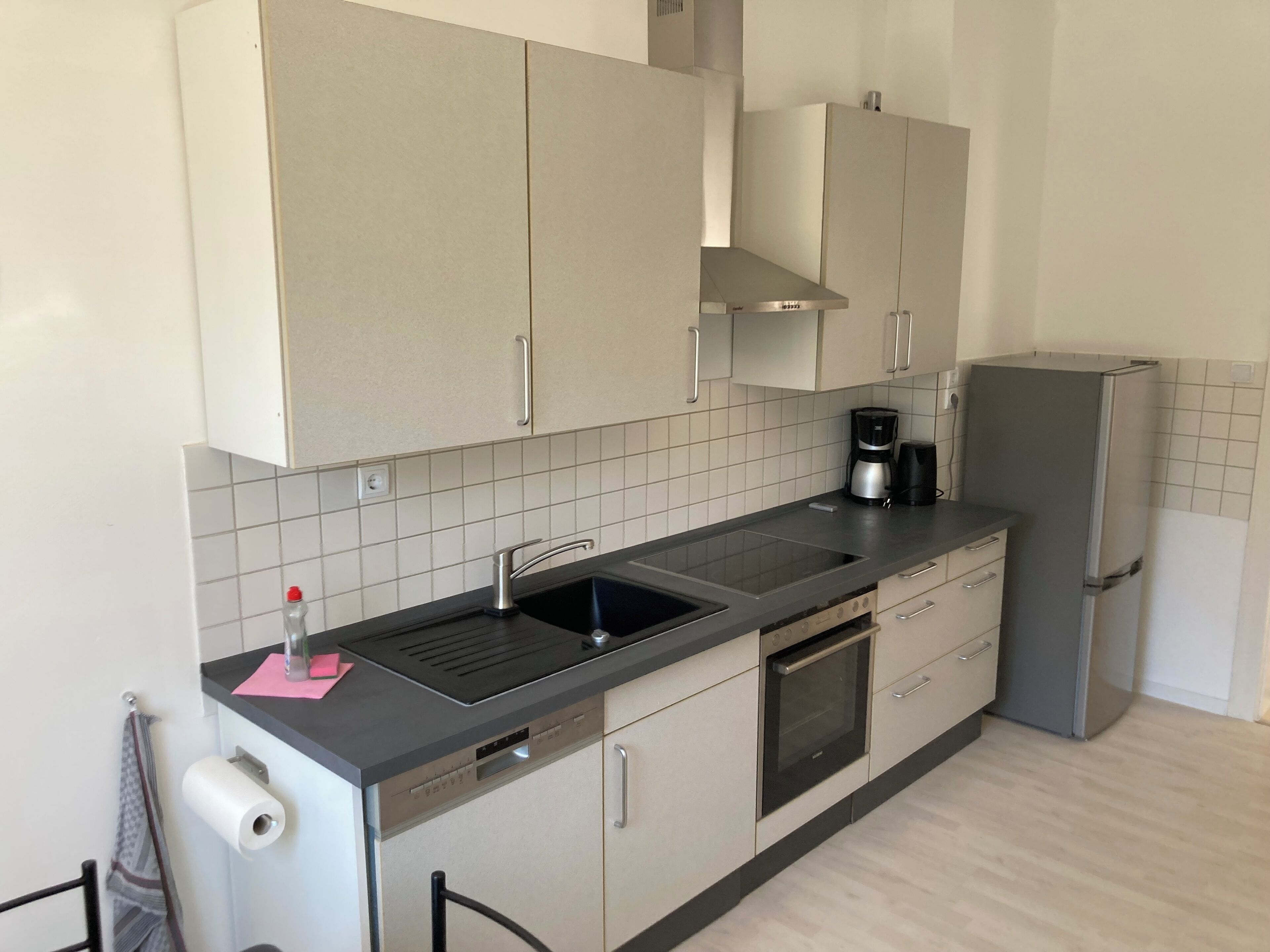 A kitchen with a sink, stove, oven, and a refrigerator.
