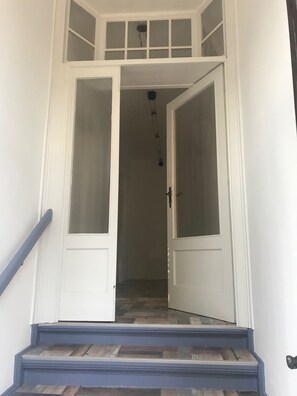 A set of double doors leading to a staircase with a blue handrail and a patterned floor. - 2-room apartment near Berlin, 72 sqm (Velten)
