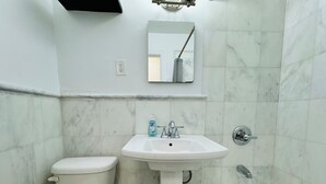 A bathroom with a toilet, sink, and bathtub.