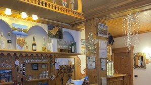 A bar area with wooden decor, shelves with bottles, and a counter with glasses.