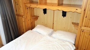 A wooden room with a bed, a shelf above the bed, and a curtain. - Flat in Nendaz Near Ski Slopes & Cable Cars (Nendaz)