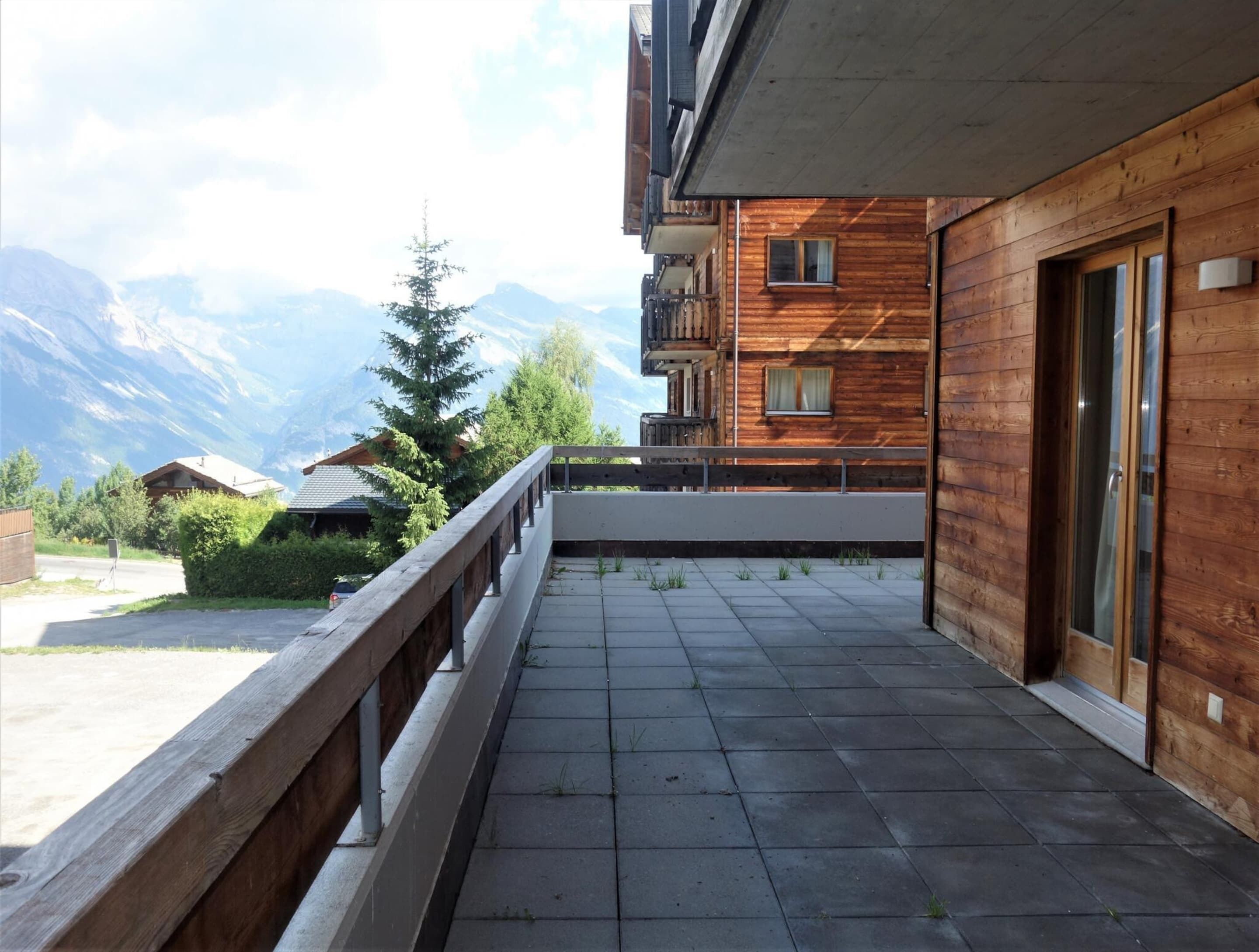 Ein Holzbalkon mit Blick auf die Berge.
