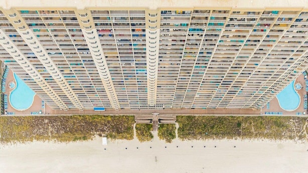 Vue aérienne d’une plage avec un grand complexe hôtelier.