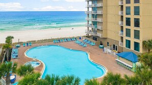 Un hôtel doté d'une piscine, offrant une vue sur la plage et comprenant plusieurs balcons.