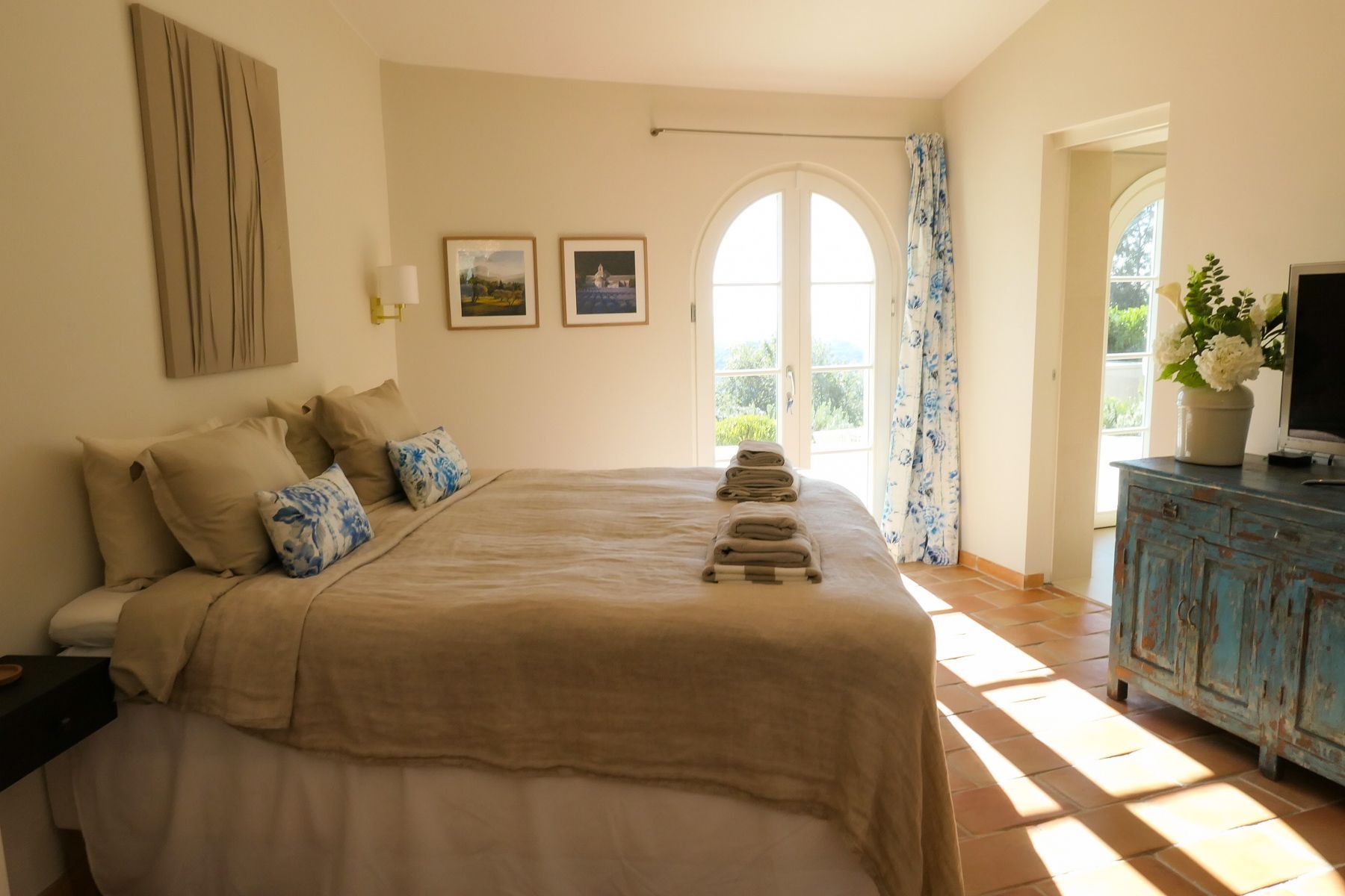 Un dormitorio con una cama grande, un aparador y una ventana con cortinas.