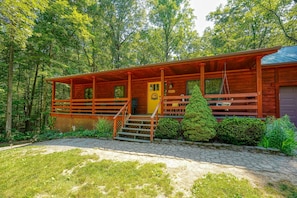 Eine Holzhütte mit Veranda, Treppe und einem kleinen Garten.