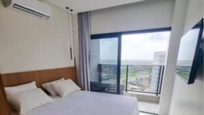 A hotel room with a bed, a TV mounted on the wall, and a balcony with a view. - SMART apartment. High floor 14. Balcony with sea view. Salinas Premium Resort. (Salinópolis)