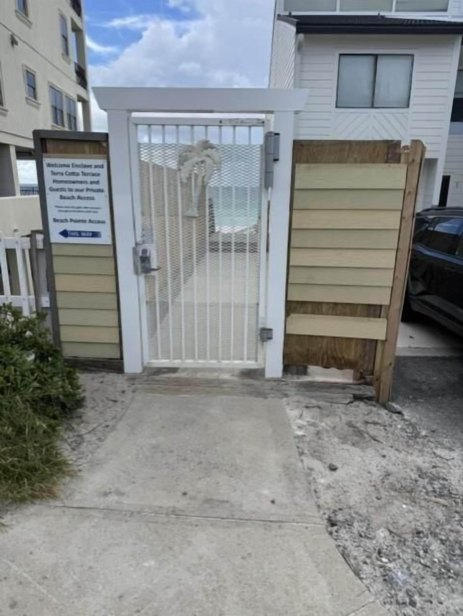 A gated entrance to a property with a sign indicating private beach access.