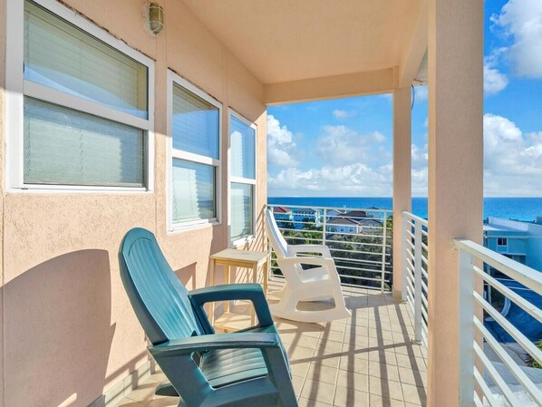 A balcony with two chairs, a table, and a view of the sea. - Carried Away (Santa Rosa Beach)