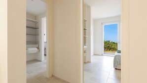 A clean, modern interior with a hallway leading to a balcony with a clear view of greenery. - Borgo Morgicchio by Perle di Puglia (Carovigno)