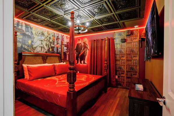 A bedroom with a large bed, a ceiling with intricate designs, and a bookshelf filled with books.