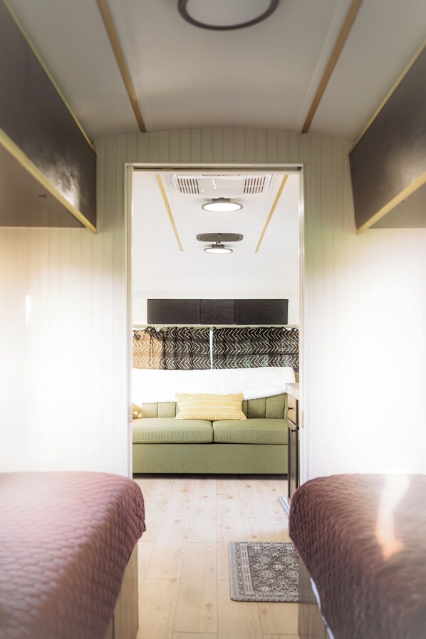 Una habitación con cama, sofá, ventilador de techo y ventana.