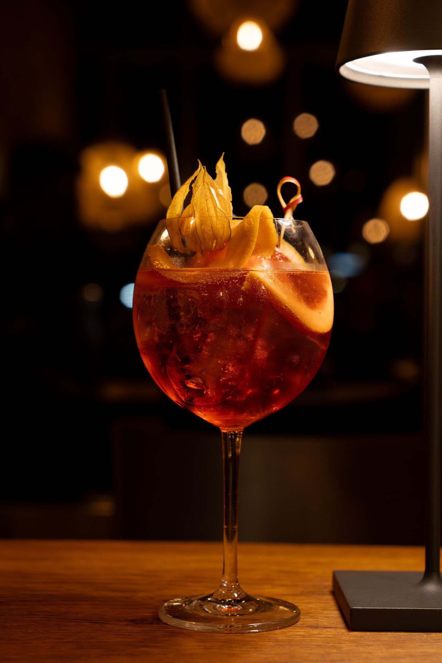 Et cocktailglas med et skiveskåret citron på et træbord.