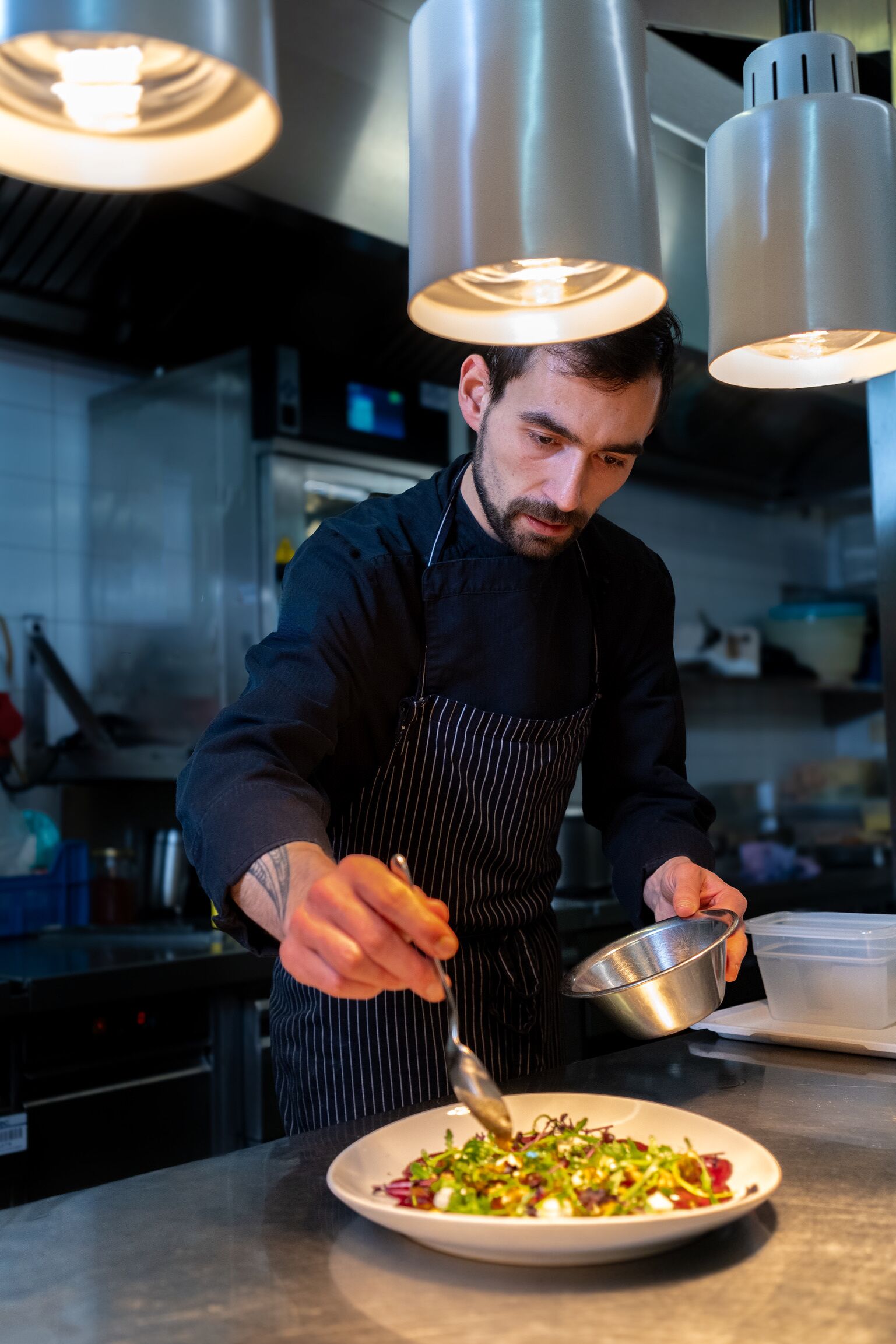 Een kok bereidt een gerecht in een keuken.