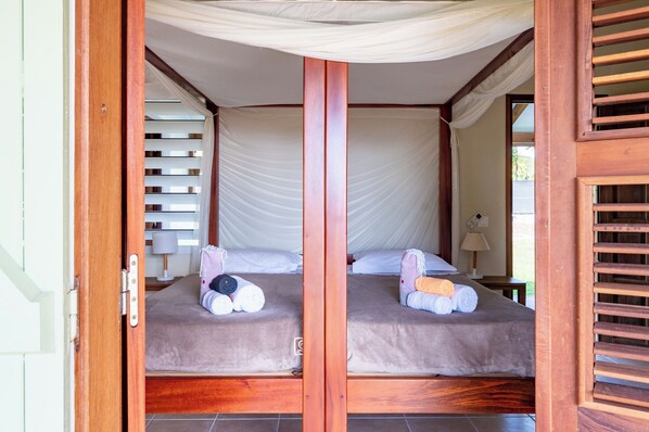 Una habitación con dos camas, cada una con dosel y almohadas.