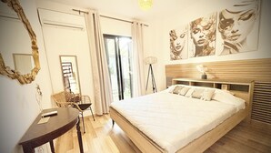 A bedroom with a large bed, a wooden headboard, a bedside table, a chair, and a floor lamp. - Ibiscus pool –5 min Walk to Beach & Pafos Harbour (Paphos)