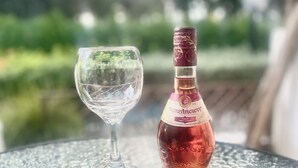 A glass and a bottle on a textured table outdoors. - Ibiscus pool –5 min Walk to Beach & Pafos Harbour (Paphos)
