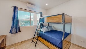 A bunk bed room with a view of a cityscape through a large window. - Apartment C25, if you are looking for tranquility, this is the right place for you!  (San José del Cabo)