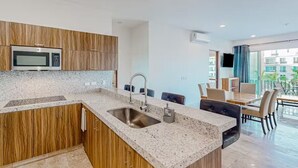 A modern kitchen with granite countertops, a stainless steel sink, and wooden cabinets. - Apartment C25, if you are looking for tranquility, this is the right place for you!  (San José del Cabo)