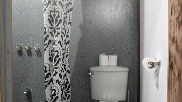 Un bagno con tenda doccia, toilette e pavimento piastrellato.