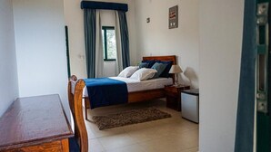 Une chambre à coucher avec un lit, une table de chevet, une lampe et un petit bureau.