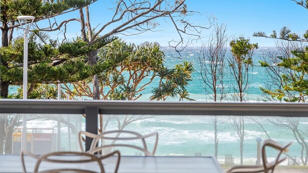 A seaside view from a balcony with chairs, a lamp post, and a clear sky. - Beach Front Beach Break - Entire Home (Byron Bay)