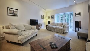 A spacious living room with two sofas, a coffee table, and a television. - Ramsgate - Coastal Cottage Escape - Pet Friendly with Parking (Ramsgate)