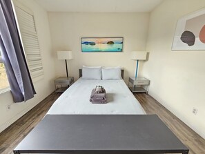 2 habitaciones, escritorio y tabla de planchar con plancha