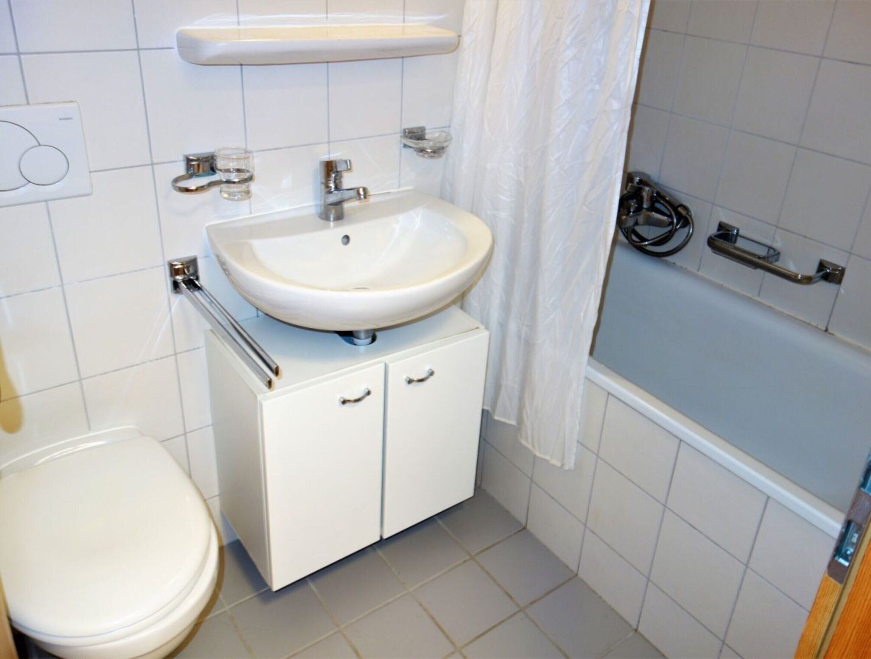 A bathroom with a white sink, toilet, and bathtub.