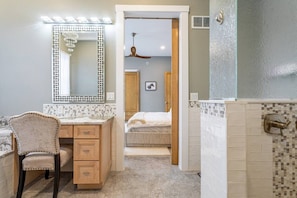 A bathroom with a vanity, a shower area, and a bedroom visible through an open door. - Equestrian Estate | Indoor Pool, Theater, Game Rm (Schoharie)
