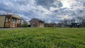 A campground with several cabins and a large grassy field. - Canal Cabins (Paw Paw)