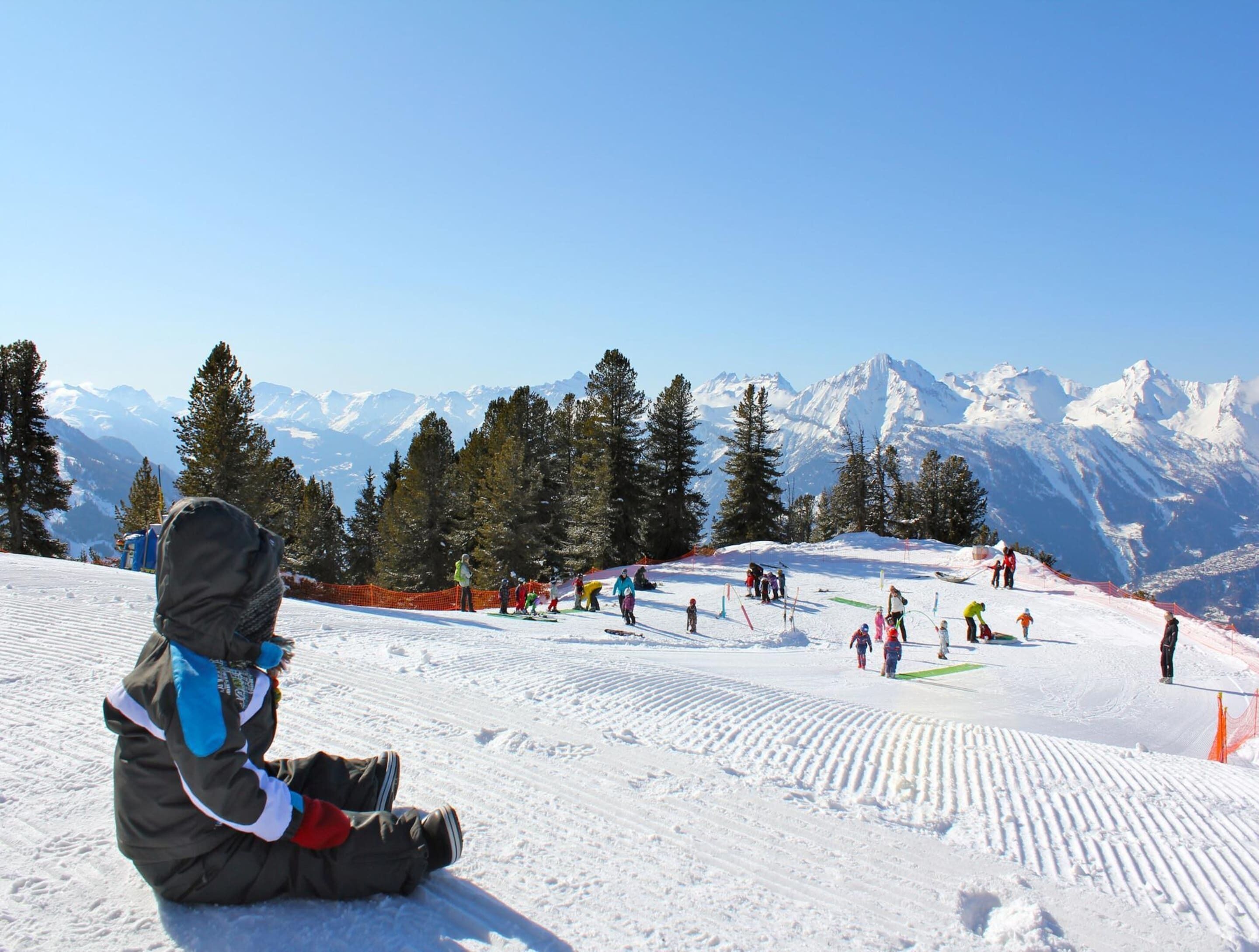 A snowy ski slope with skiers and snowboarders.