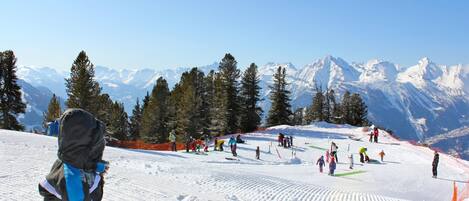 A snowy ski slope with skiers and snowboarders.
