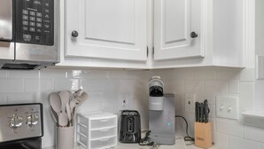 A kitchen with white cabinets, a coffee maker, a toaster, and a knife block. - Charming 2-Bedroom Home...Pet Friendly...2 Min From Baptist East (Montgomery)