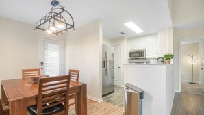 A modern kitchen with white cabinets, a stainless steel refrigerator, and a microwave. - Charming 2-Bedroom Home...Pet Friendly...2 Min From Baptist East (Montgomery)