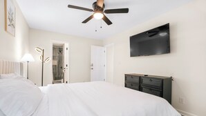 A bedroom with a bed, a ceiling fan, a TV mounted on the wall, and a dresser. - Charming 2-Bedroom Home...Pet Friendly...2 Min From Baptist East (Montgomery)