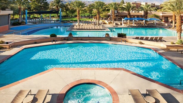 A large, multi-level swimming pool with clear blue water, surrounded by lounge chairs and palm trees. - LUXURIOUS MARRIOTT VACATION RESORT, MINUTES FROM FESTIVAL GROUNDS (Palm Desert)