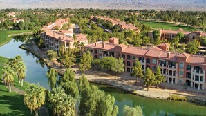 A resort with multiple buildings, a lake, and surrounding greenery. - LUXURIOUS MARRIOTT VACATION RESORT, MINUTES FROM FESTIVAL GROUNDS (Palm Desert)