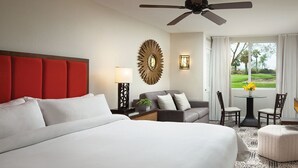 A hotel room with a large bed, a sofa, a small table with chairs, a ceiling fan, and a view of the outdoors. - LUXURIOUS MARRIOTT VACATION RESORT, MINUTES FROM FESTIVAL GROUNDS (Palm Desert)