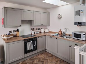 A modern kitchen with grey cabinets, a microwave, a sink, and a toaster.