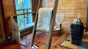 A wooden interior with a ladder, a window, and a stove. - Rustic barn on organic farm in South Head (South Head)