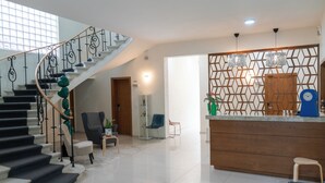 A modern interior with a staircase, a kitchen area, and a seating area. - FCH Hotel Minerva-CAS (Guadalajara)