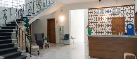 Un interior moderno con una escalera, una zona de cocina y una sala de estar.
