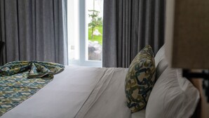 A hotel room with a bed, a patterned throw blanket, and a pillow with a camouflage design. - FCH Hotel Minerva-CAS (Guadalajara)