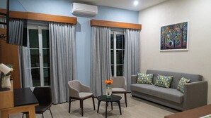 A modern living room with a grey sofa, two armchairs, a small round table, and a painting on the wall. - FCH Hotel Minerva-CAS (Guadalajara)