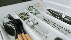 Un tiroir de cuisine contenant des ustensiles, notamment une râpe, des spatules et un couteau.