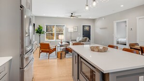A modern kitchen with a large island, stainless steel appliances, and pendant lighting. - NEW Dream Weaver - 5 min Walk to Main Street! (Weaverville)