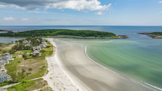 An aerial view of a coastal area with a sandy beach, a residential area with houses, and a forested peninsula. - Pet Friendly-Updated Goose Rocks Beach Oasis! (Kennebunkport)