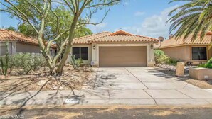 A residential property with a garage, a driveway, and a well-maintained lawn. - Upgraded entire residential home (Scottsdale)